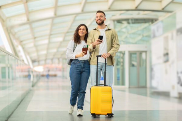 Mann und Frau mit Trolley Koffer am Flughafen